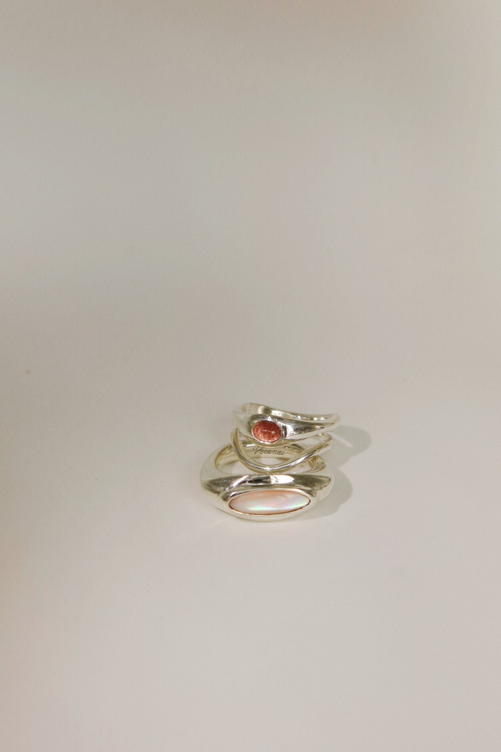 Silver ring with a red stone on a light gray background