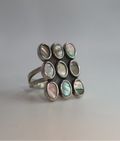 Silver ring with circular gemstones on a light gray background