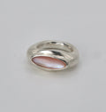 Silver ring with pink gemstone on a light gray background