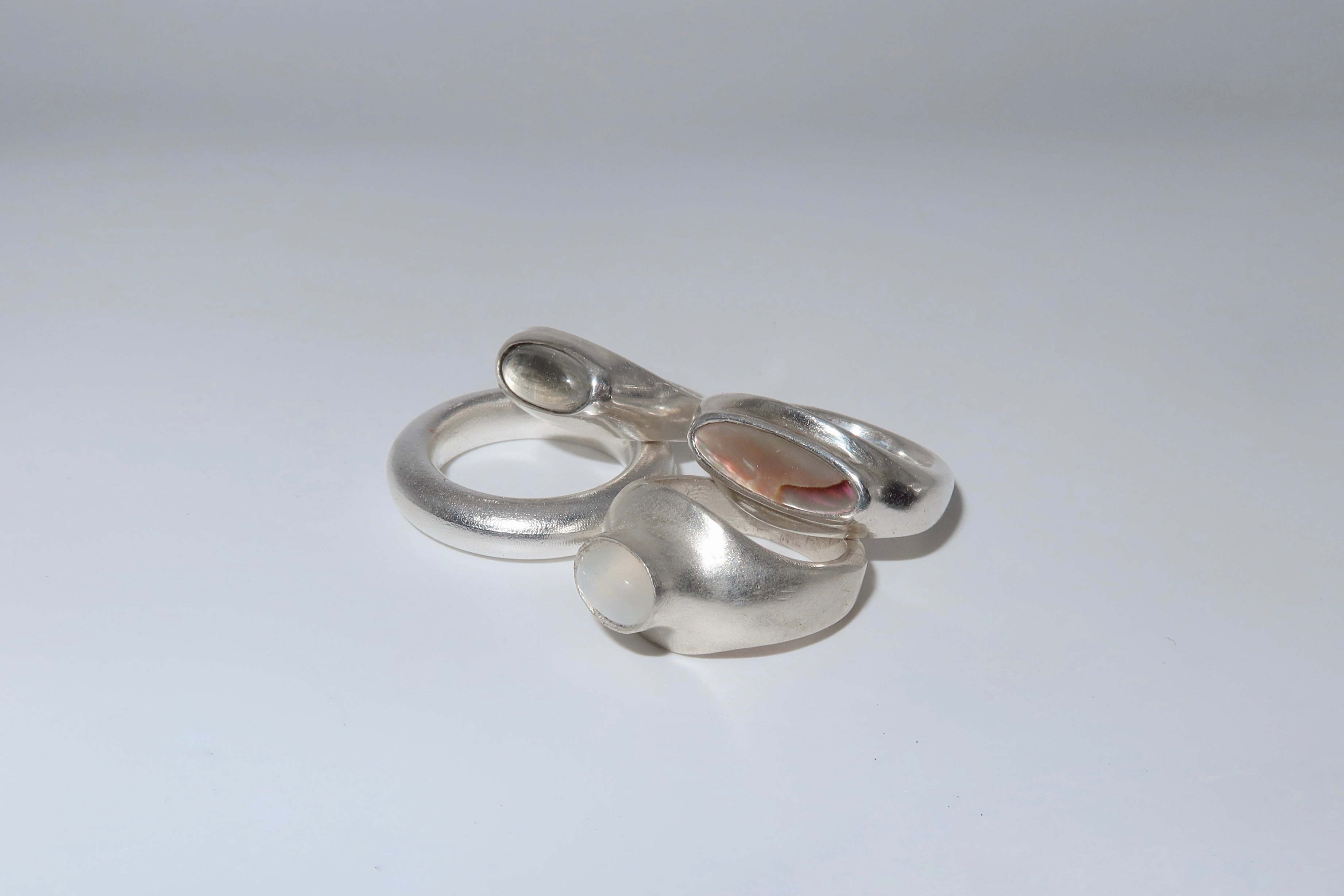 Silver ring with a small pendant on a light gray background
